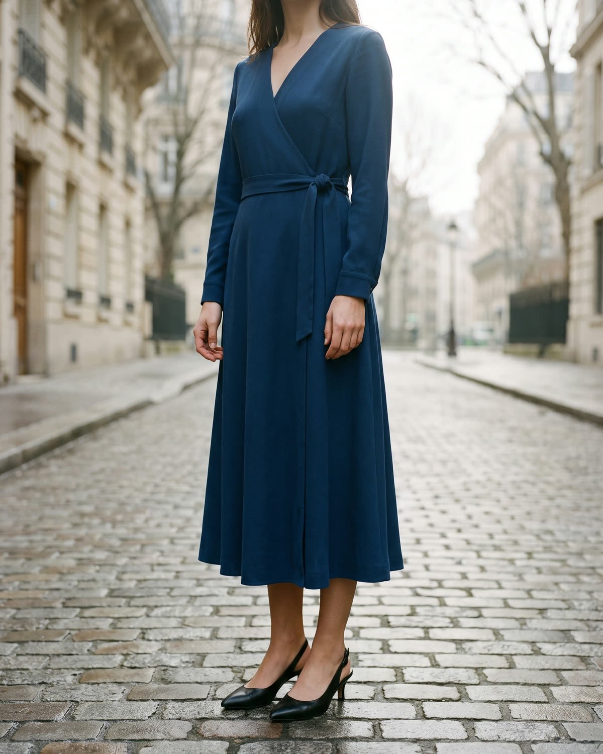 Robe Palais portée dans une rue de Paris&nbsp;: robe portefeuille midi en crêpe de laine bleu encre.